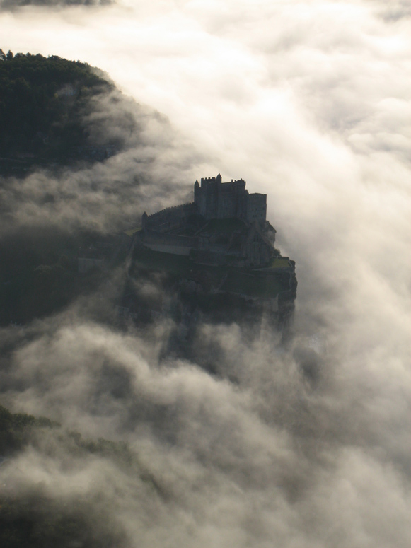 Survol du châteaux de Beynac avec la brume sur la Dordogne