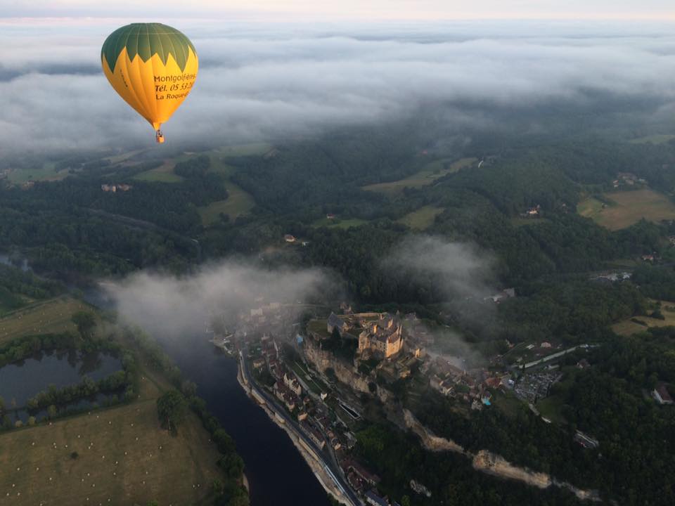 Photo représentant une montgolfière survolant la vallée de la Dordogne et le chateau de Castelnaud-la-Chapelle