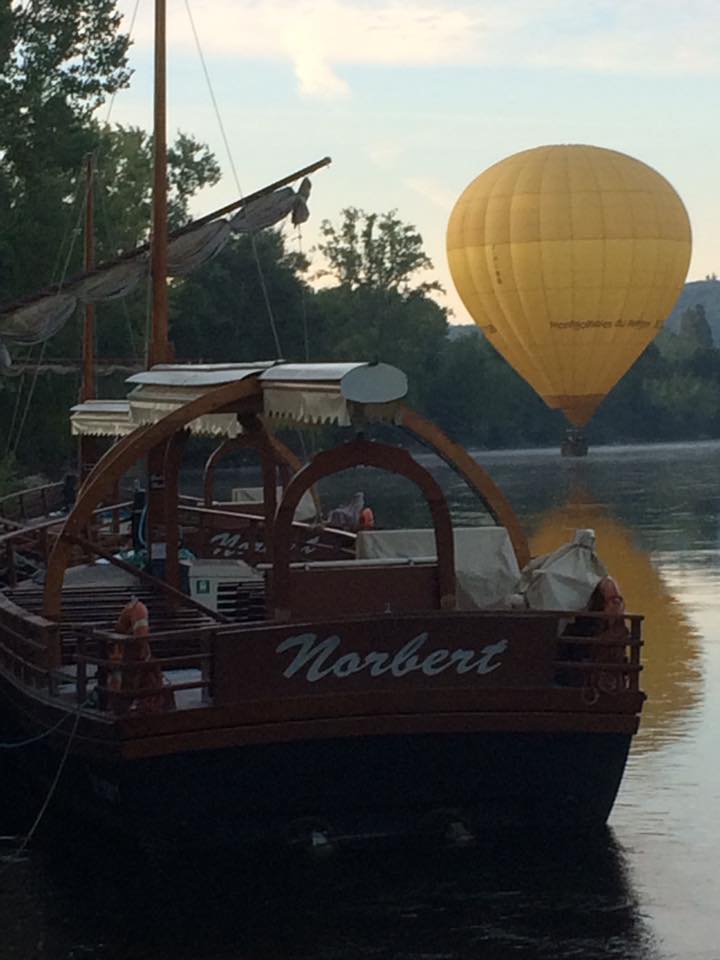 Photo représentant une montgolfière frôlant la rivière Dordogne à La Roque-Gageac devant les Gabarres Norbert
